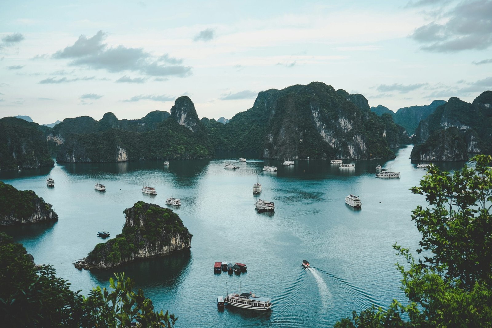 high-angle photography of boats on water near hill during daytime